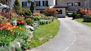 Une maison à deux étages avec une allée pavée menant à l’entrée.