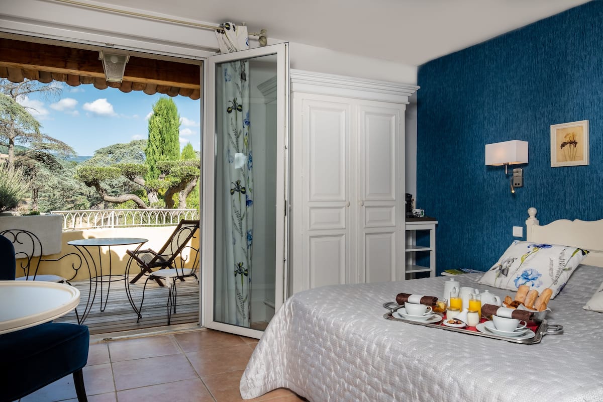 Un dormitorio con cama, bandeja de desayuno y vistas al exterior.