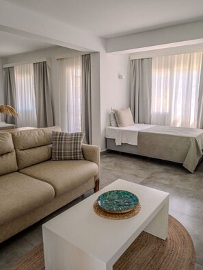 A modern living room with a sofa, a bed, and a coffee table. - Hotel Gumusluk (Bodrum)