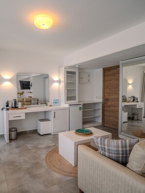 A modern, well-lit room with a white desk, a sofa, and a large mirror. - Hotel Gumusluk (Bodrum)