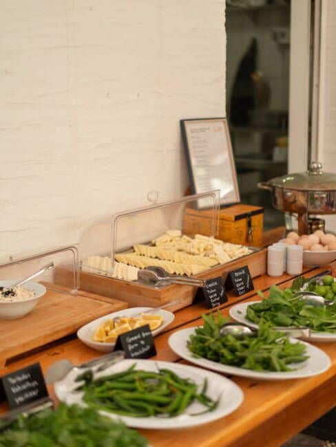 Een buffetopstelling met diverse gerechten en een menubord.