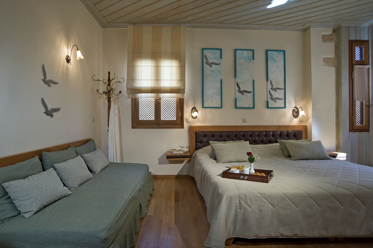 A bedroom with two beds, a nightstand, and wall art.