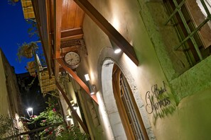 Fachada de hotel con un reloj, ventanas arqueadas y un letrero que dice 'Hotel Churves'.