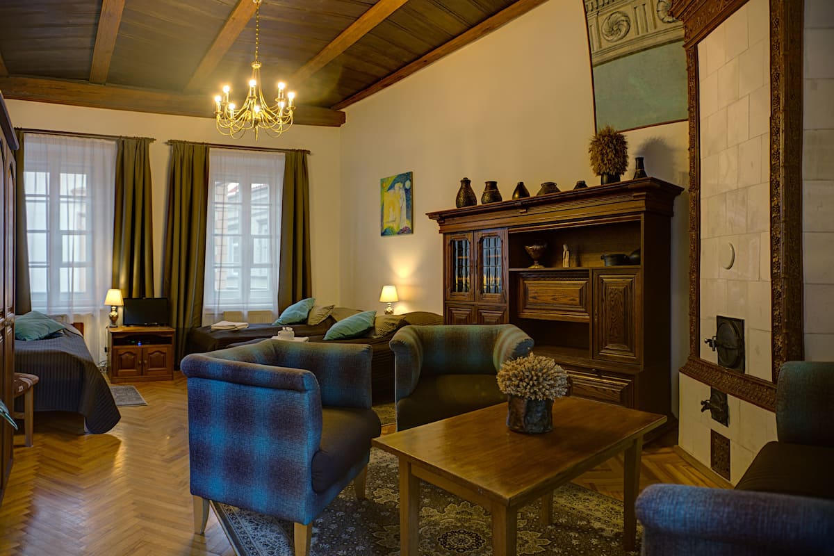 A cozy living room with a sofa, armchairs, a wooden coffee table, and a television.