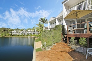 A waterfront property with a balcony, a wooden deck, and a view of the water. - Portside Noosa Waters (Noosaville)
