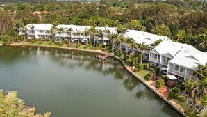 A resort with multiple white buildings, a lake, and lush greenery. - Portside Noosa Waters (Noosaville)