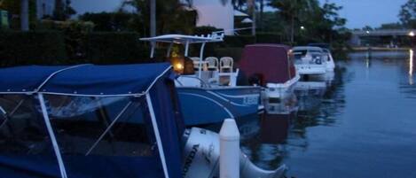A boat docked at a marina with a covered seating area and a white cabin.