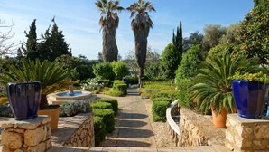 A garden pathway with palm trees, a fountain, and various plants. - Quinta Bonita Luxury Boutique Hotel (Lagos)