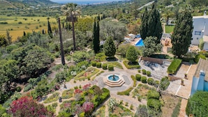 A garden with a fountain, a pool, and a view of the sea. - Quinta Bonita Luxury Boutique Hotel (Lagos)