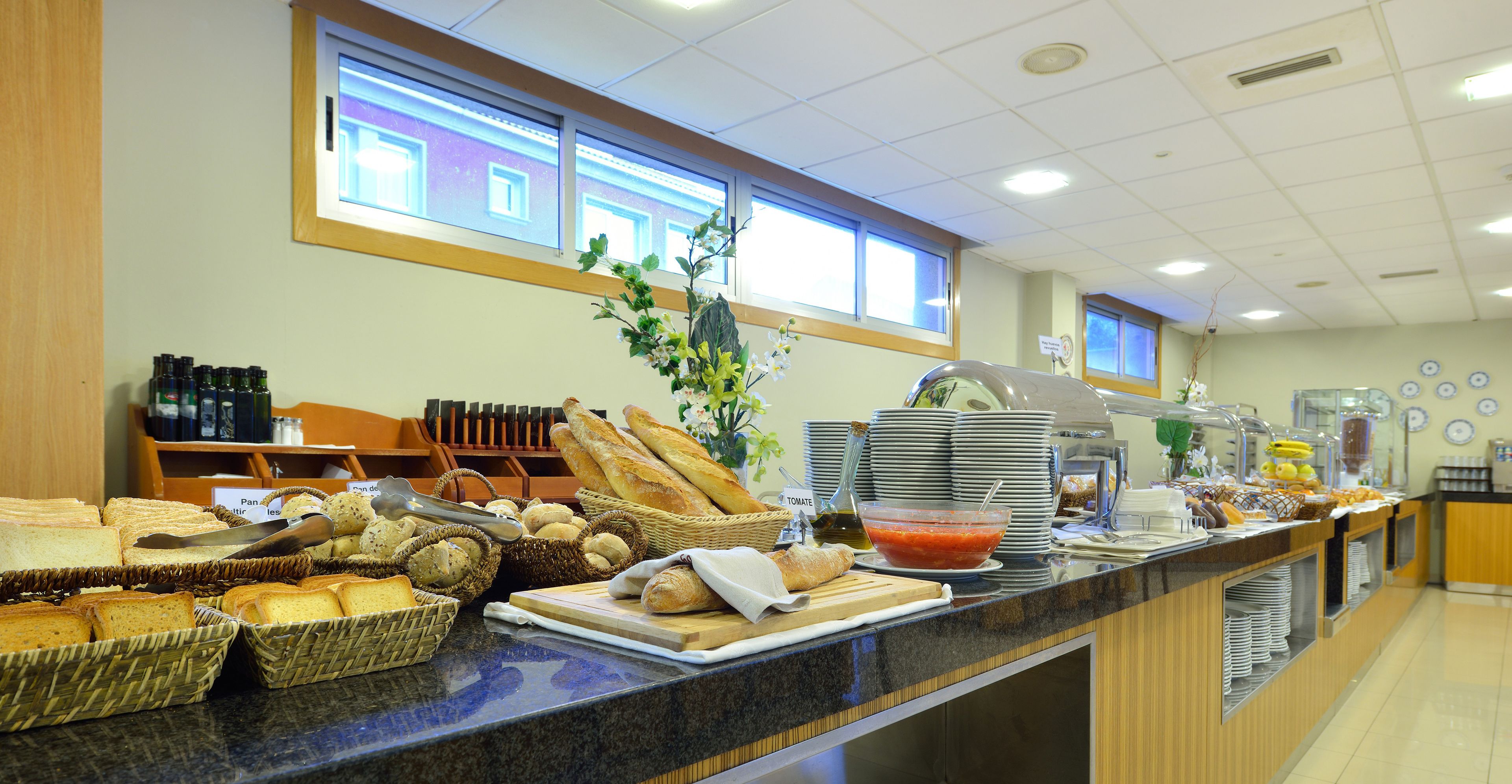 Un buffet proposant une variété de pains, de viennoiseries et un assortiment de salades.