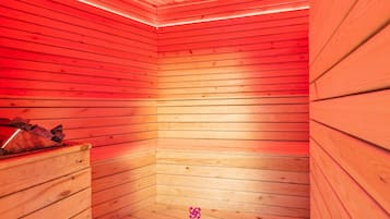 A sauna with wooden walls and a bench, featuring a logo at the bottom.