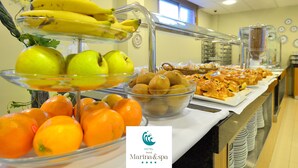 Un bufé con frutas y productos de pastelería.