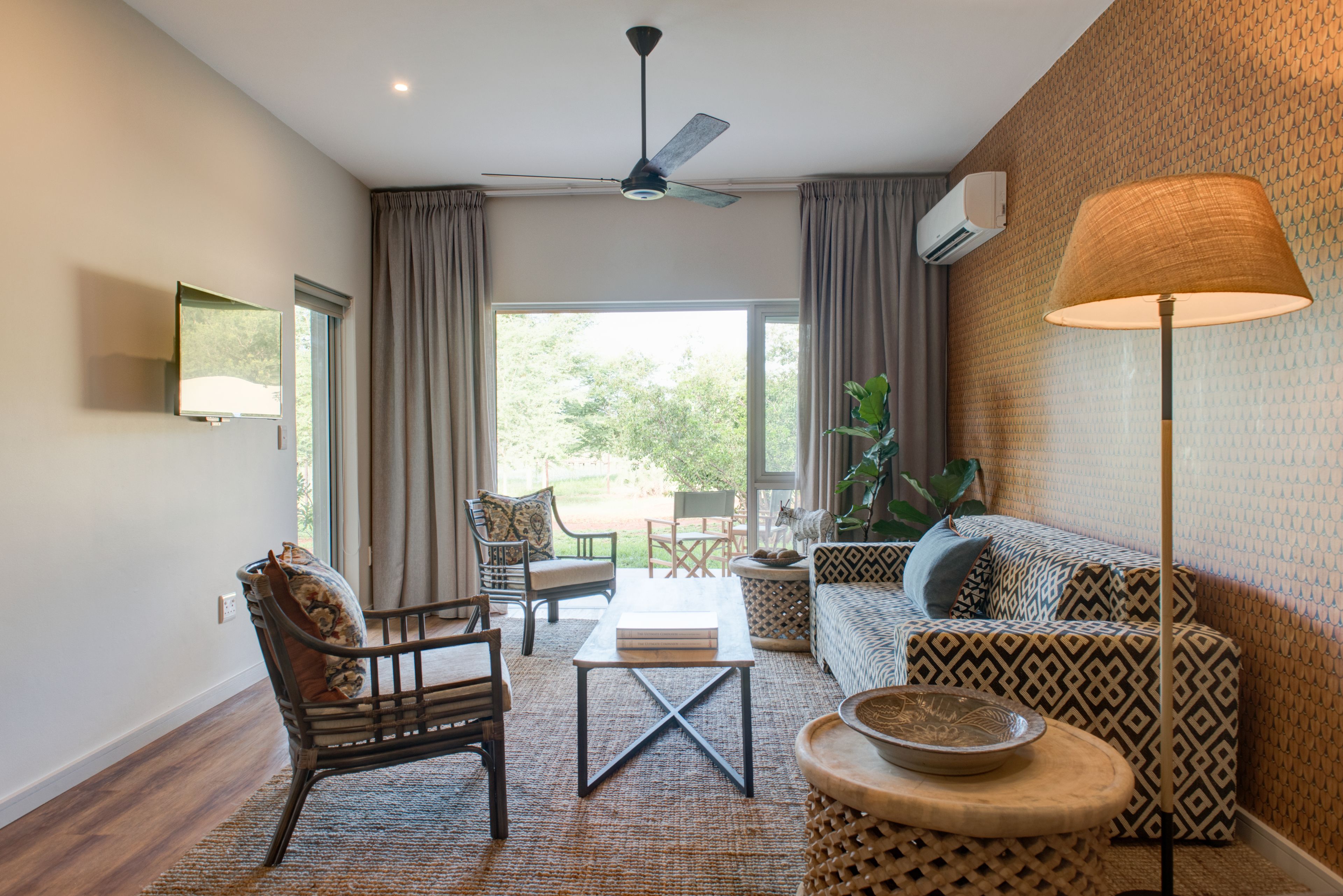 A living room with a sofa, armchair, coffee table, and a ceiling fan.