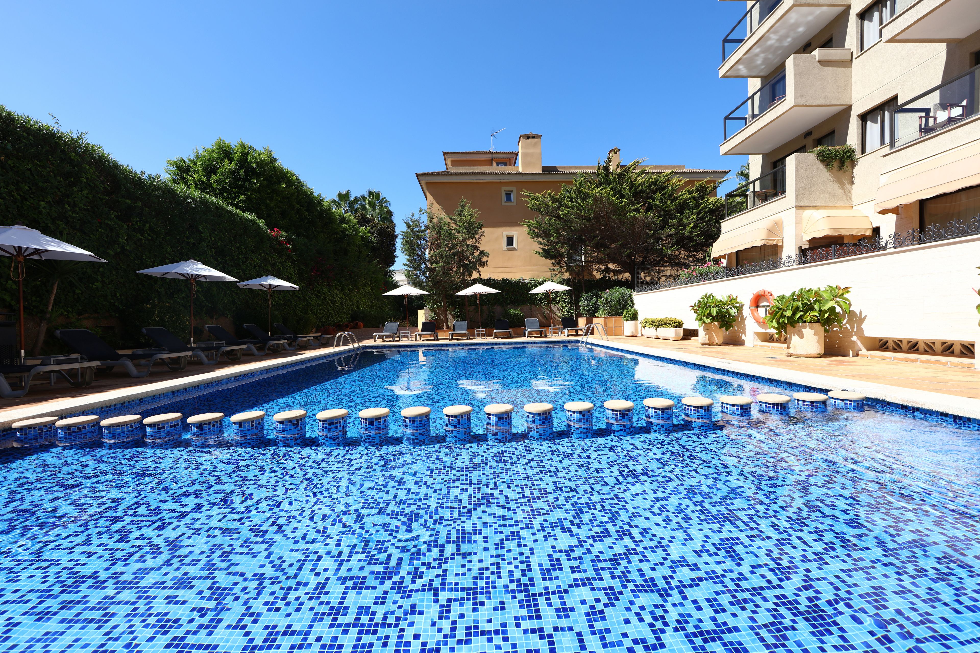 Una piscina al aire libre, tumbonas