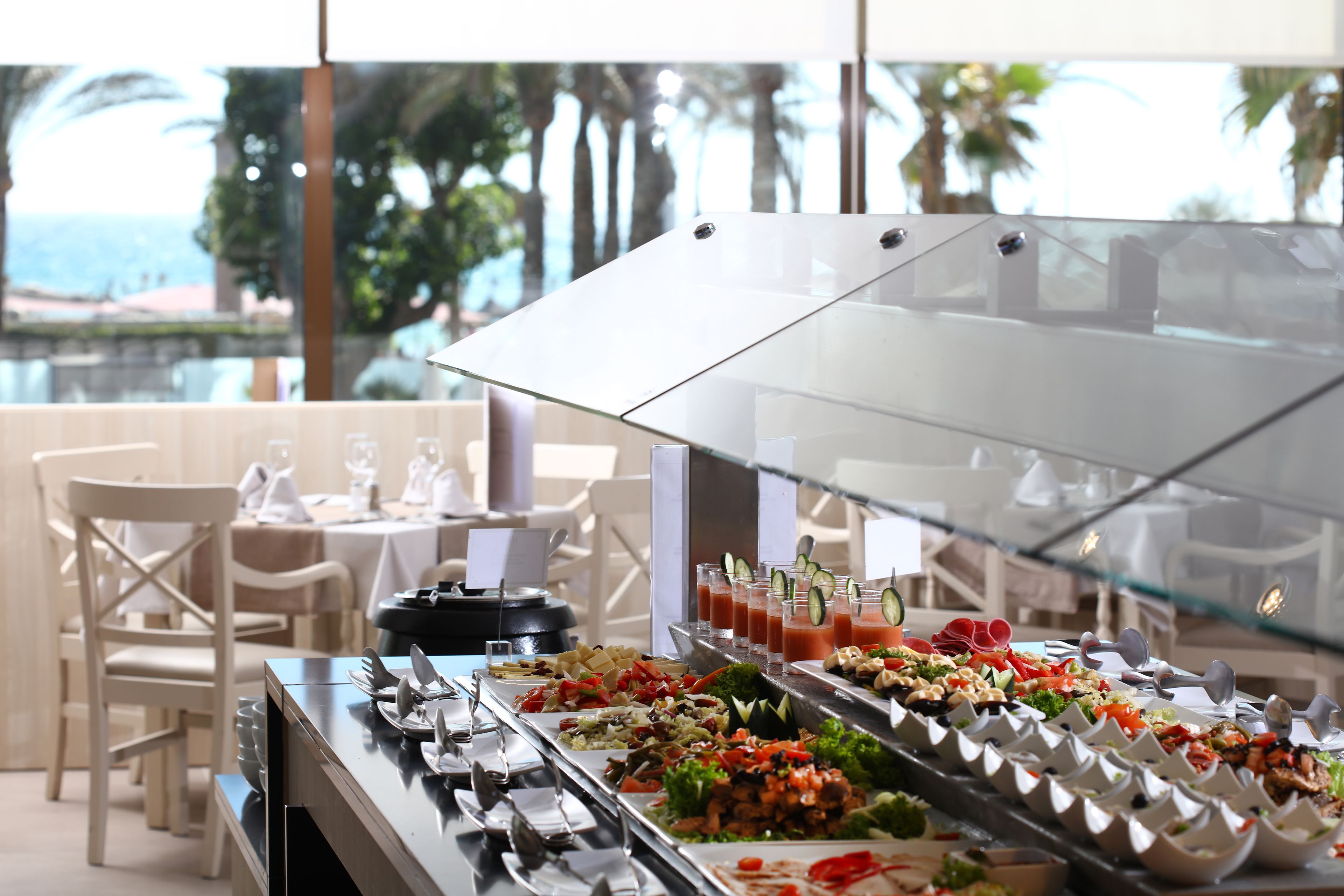 Un buffet proposant une variété de plats et une cloison en verre.