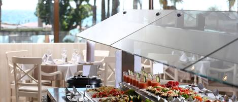 Un buffet proposant une variété de plats et une cloison en verre.
