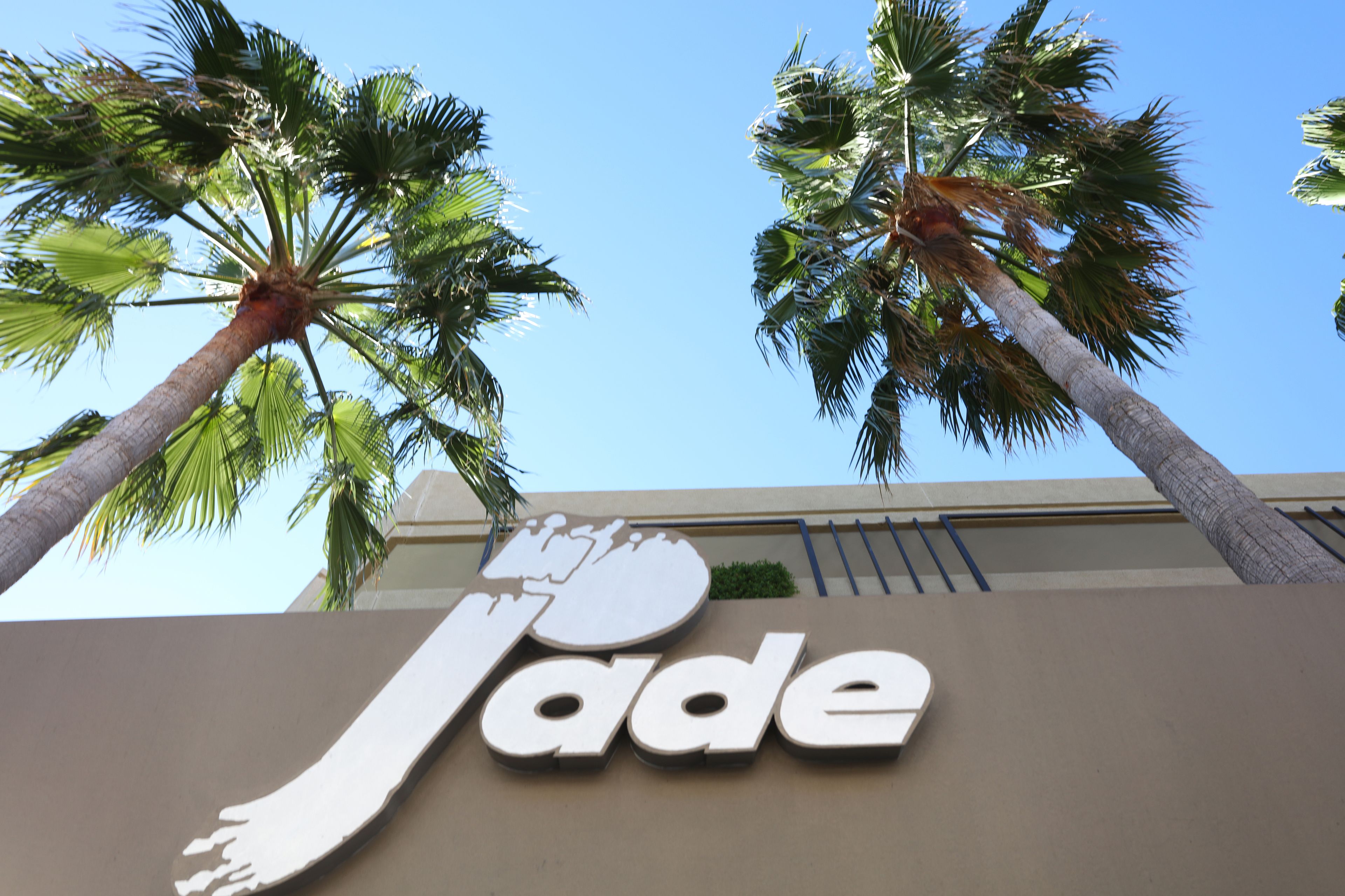 Cartell de 'Jade' amb palmeres al fons.