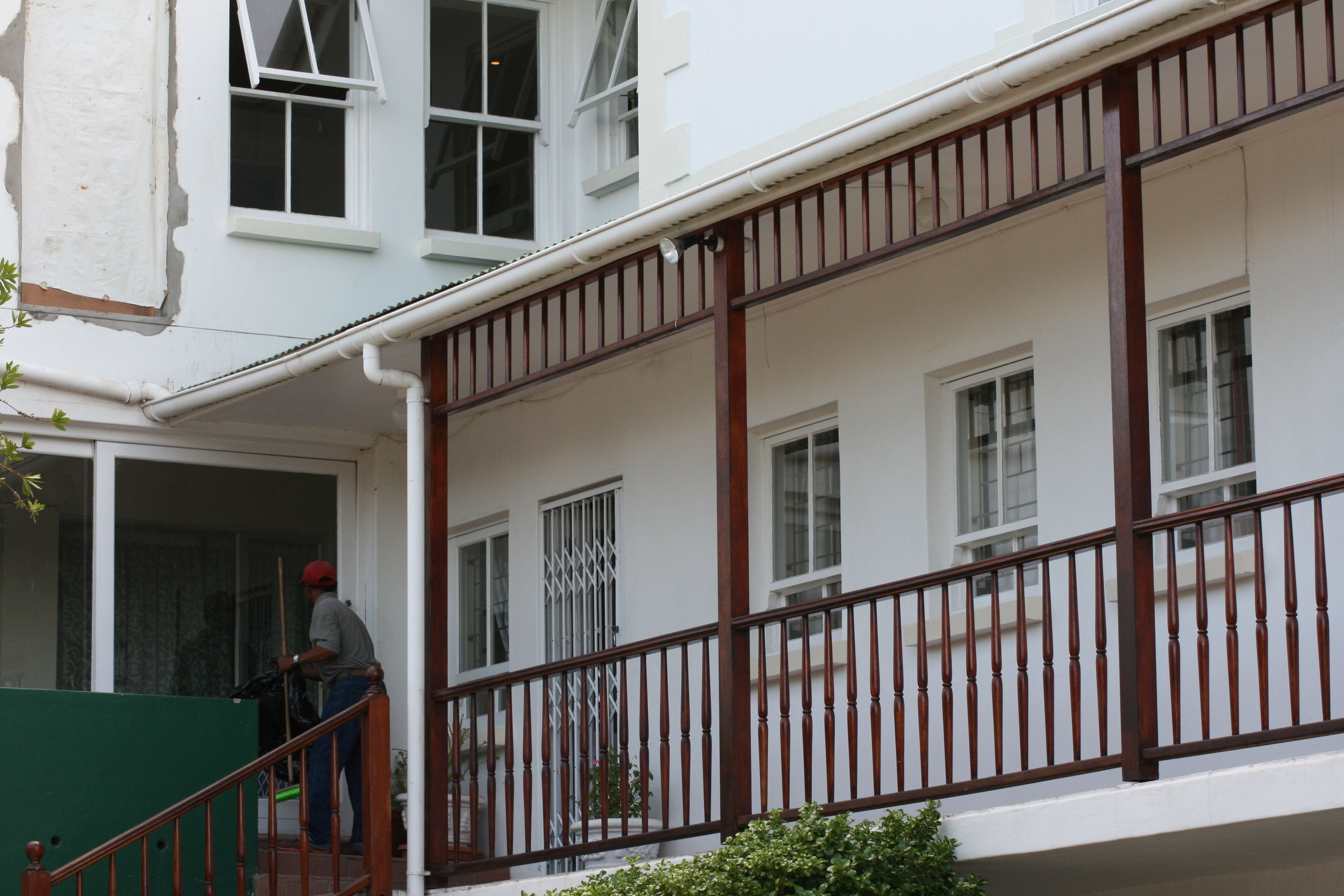 Un edificio de dos pisos con un balcón y una escalera.