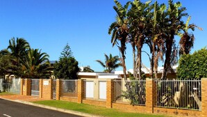 A residential property with a brick exterior, a gated entrance, and a well-maintained lawn. - Hajo's Lodge & Spa (Cape Town)