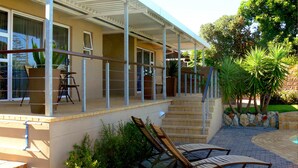 A covered outdoor area with a pool, steps leading to a door, and outdoor seating. - Hajo's Lodge & Spa (Cape Town)