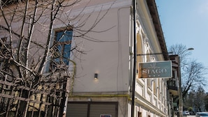 A building with a sign reading 'SIAGO' and a closed garage door with a sign indicating no parking.