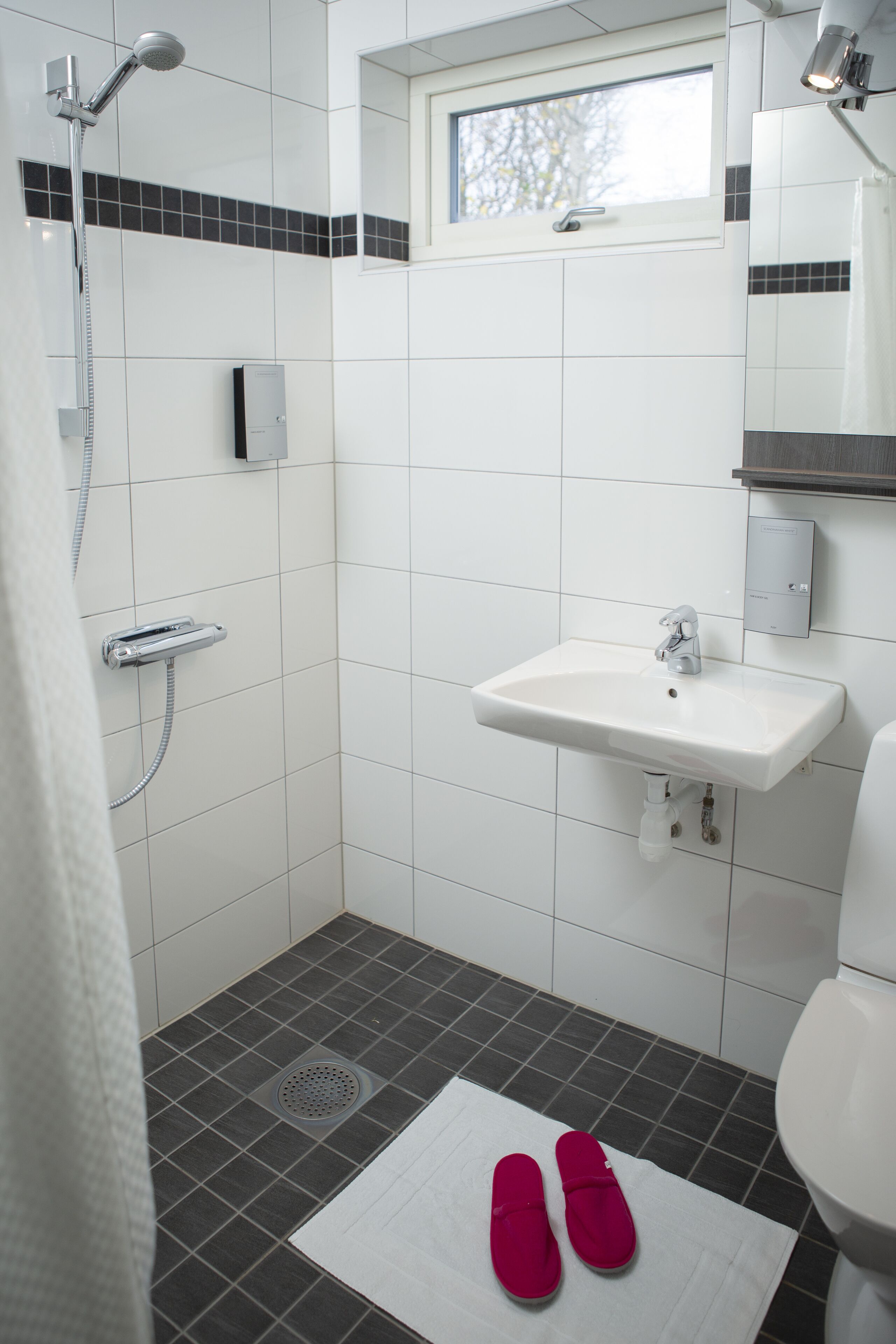 A bathroom with a shower, sink, and toilet.