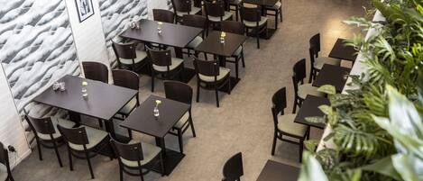 A restaurant with multiple tables and chairs arranged in a spacious layout.