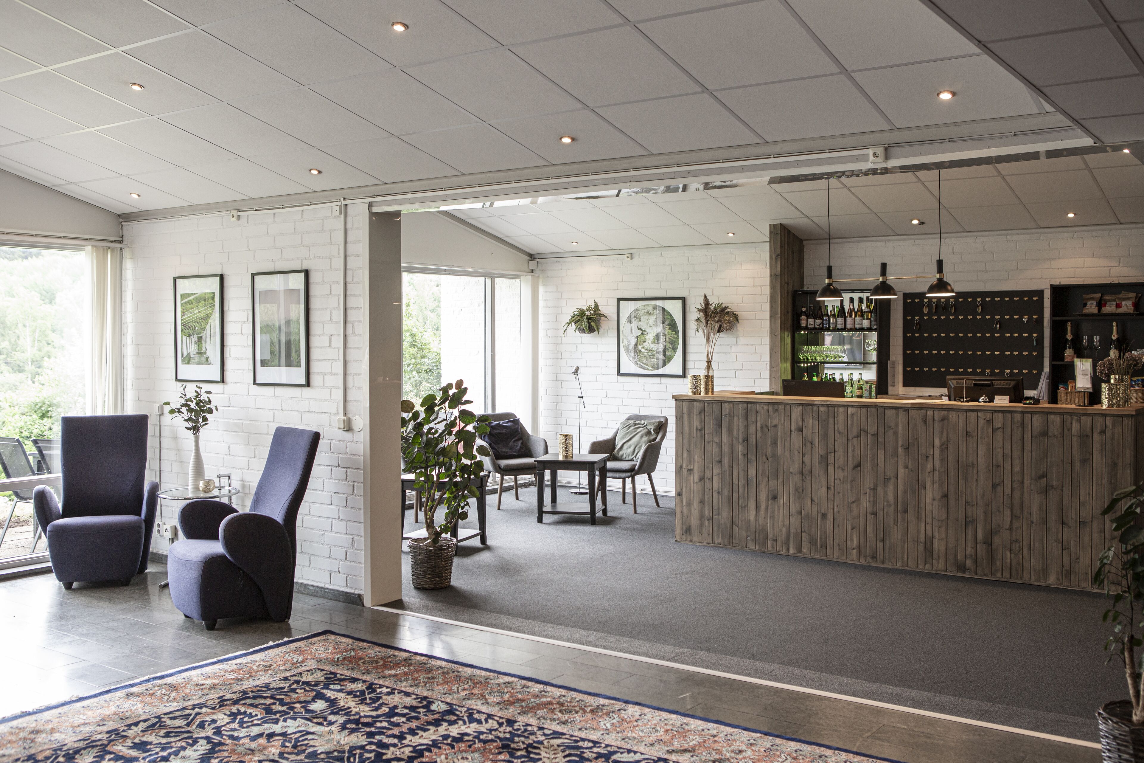 A spacious lobby with a reception desk, seating area, and large windows.