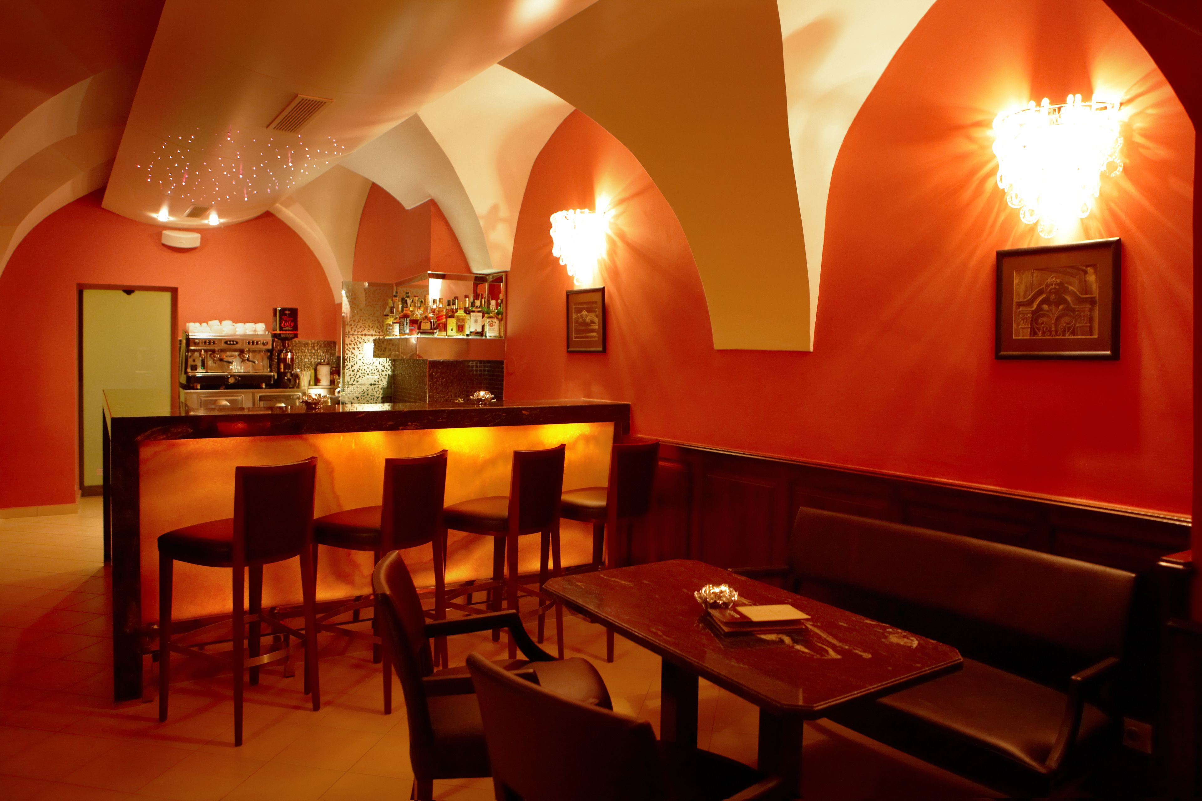 Un restaurante con barra, mesas en cabinas y mostrador.