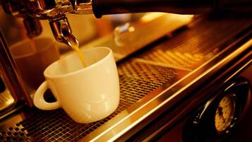 Une machine à café verse du café dans une tasse blanche.