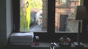 A bathroom with a sink, a towel, and a window overlooking a building with a tiled roof. - Relais Palazzo Paleologi - Secolo XIV (Lu e Cuccaro Monferrato)