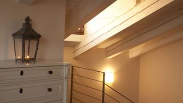 A staircase with a railing, a white dresser with drawers, and a lantern on top.