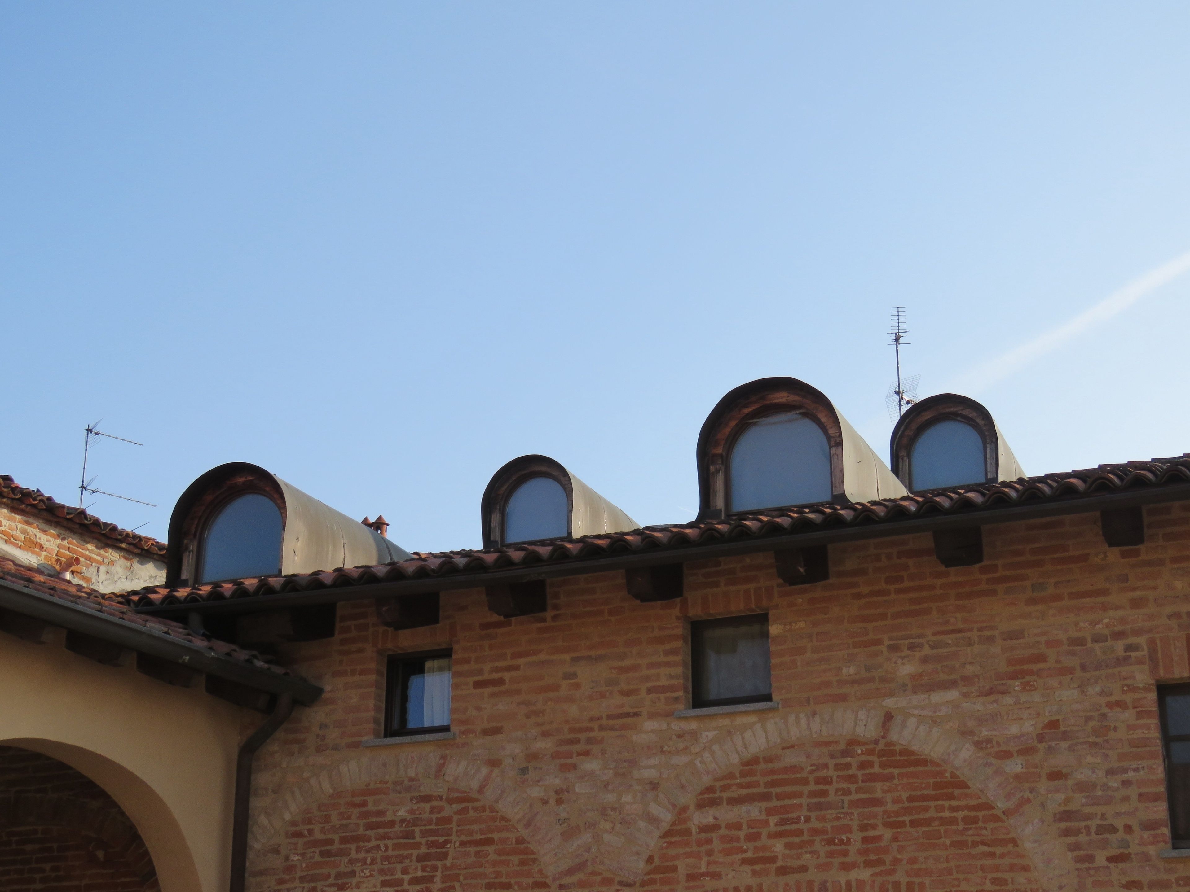 A building with multiple arched windows and a tiled roof.