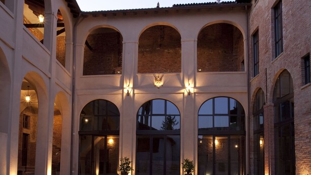 An open courtyard with arches, brick walls, and potted plants. - Relais Palazzo Paleologi - Secolo XIV (Lu e Cuccaro Monferrato)