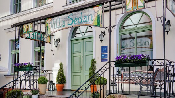 Un edificio con una puerta verde y un letrero que dice "Villa Sedan".