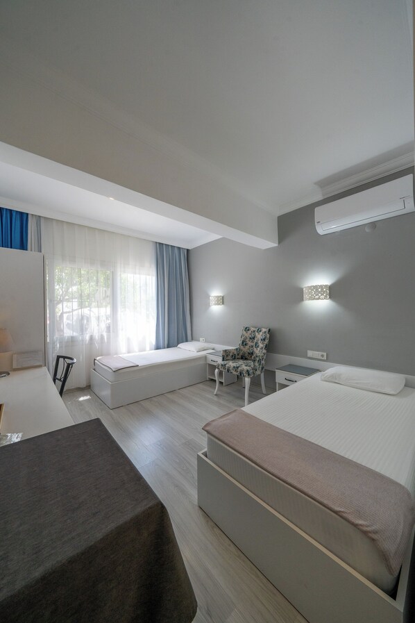Una habitación de hotel moderna con cama, escritorio, silla y una mesita.