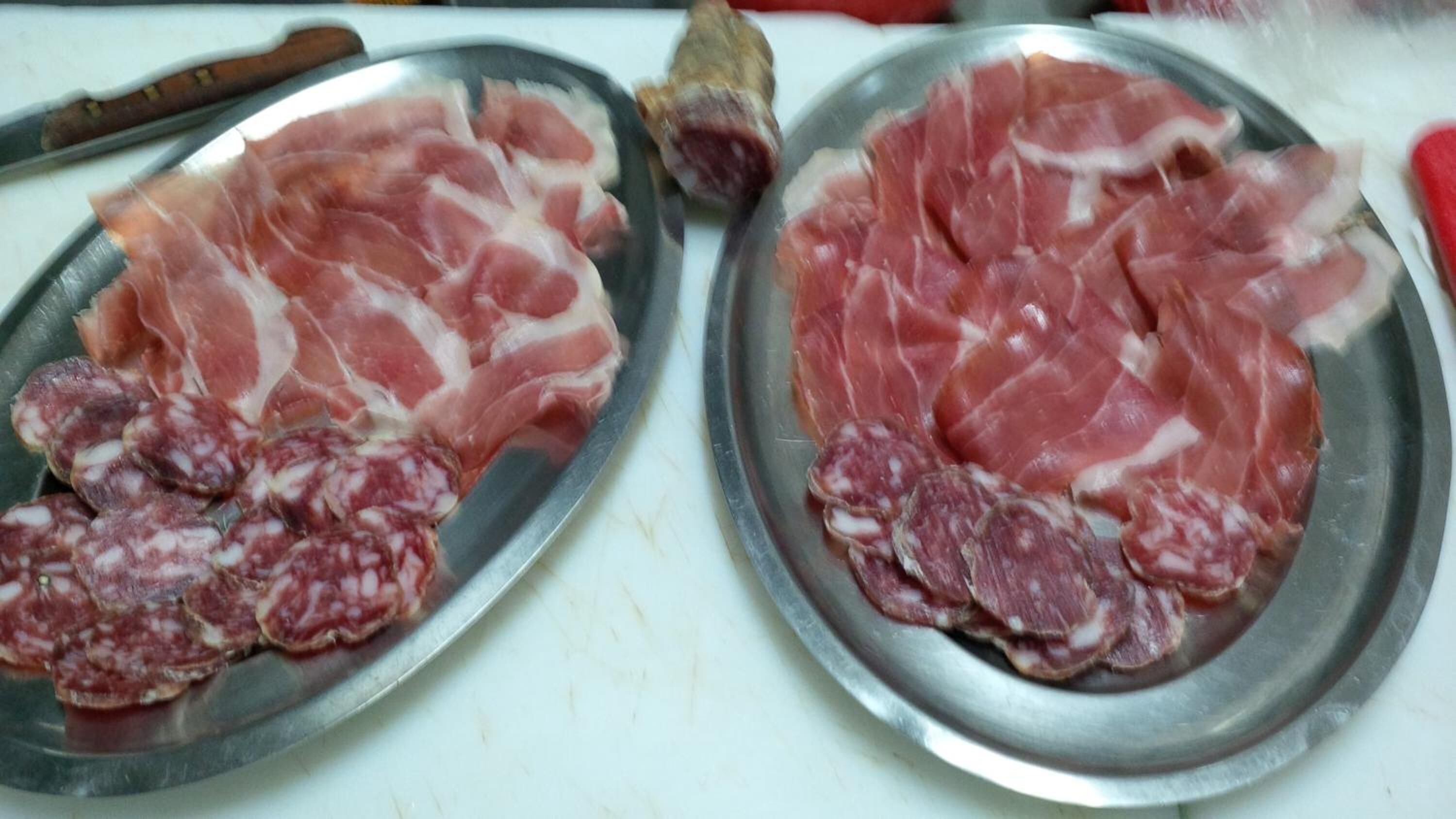 Deux assiettes en métal garnies de tranches de charcuterie.