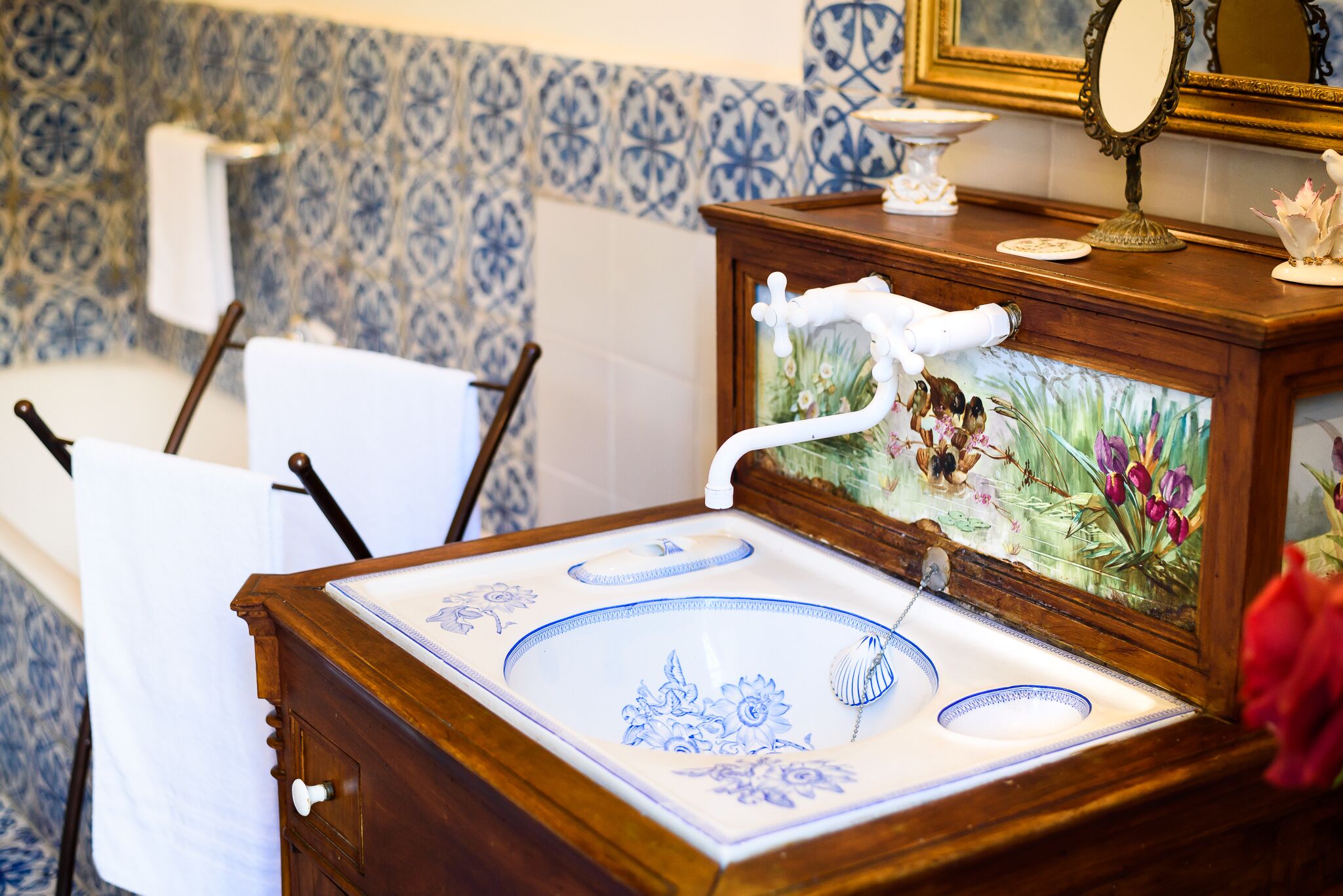 Une salle de bain avec un lavabo, un miroir et un mur décoratif.