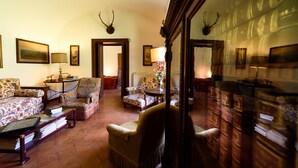 Una habitación tradicional con sofá, sillones, una mesita y un espejo.