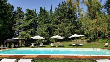 Een buitenzwembad en ligstoelen