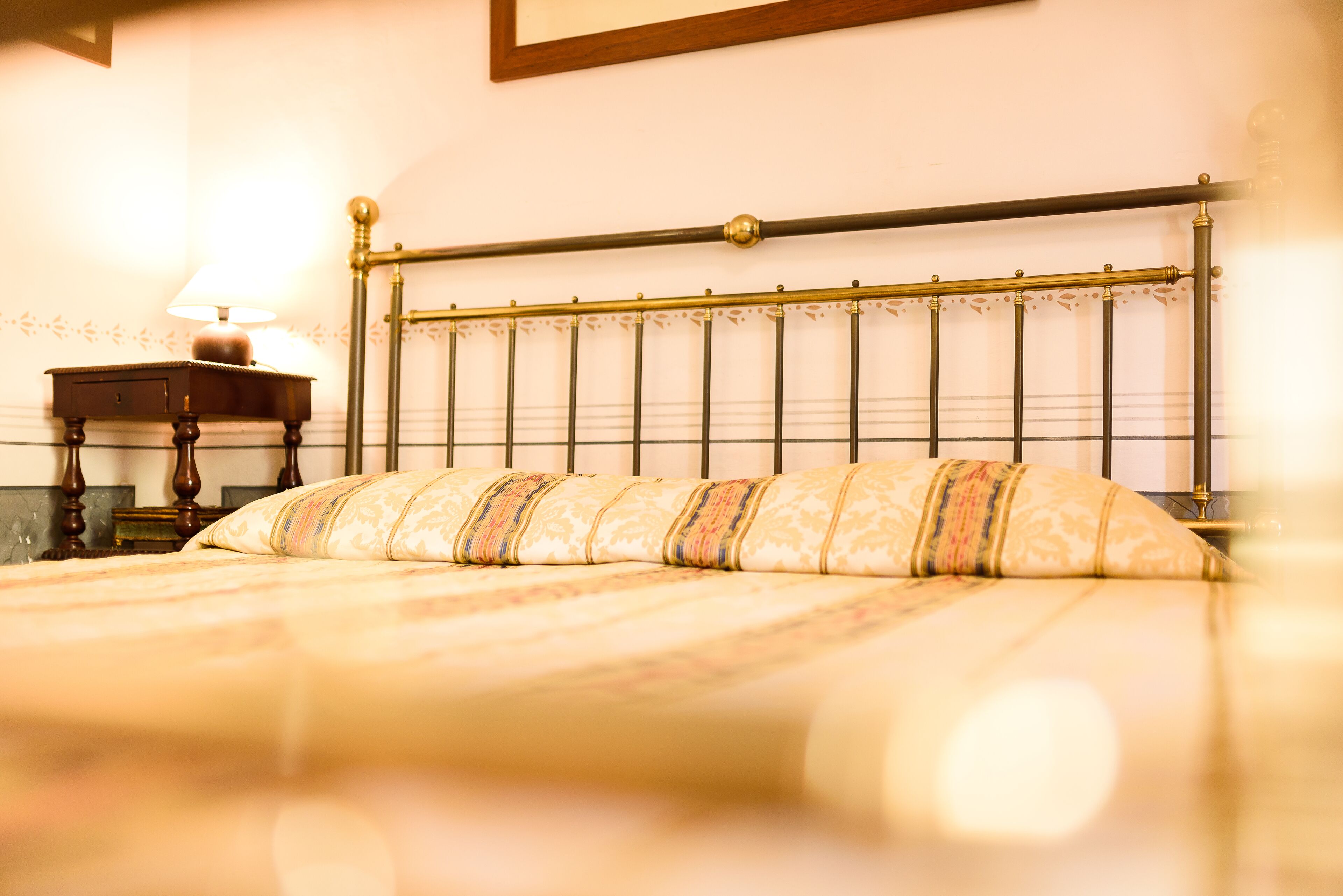 Un lit bien fait, avec un oreiller à motifs et une tête de lit ornée d’un motif décoratif.