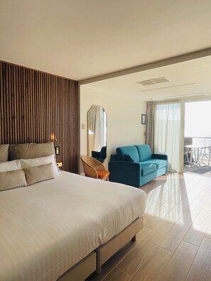 Junior suite, uitzicht op zee | Een minibar, een kluis op de kamer, een bureau, verduisterende gordijnen