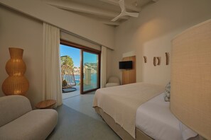 A hotel room with a large bed, a sofa, a TV, and a view of the outdoors.