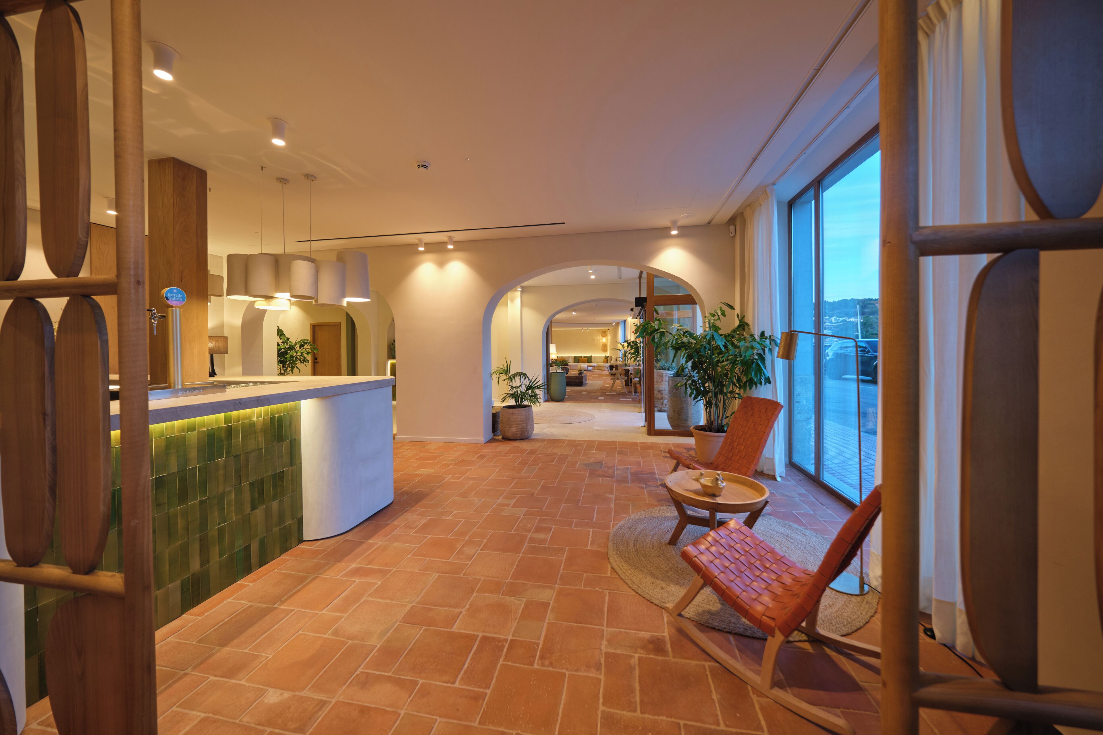 A spacious indoor area with a reception desk, seating area, and large windows offering a view.