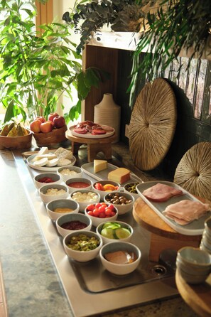 A buffet table with various food items and condiments.