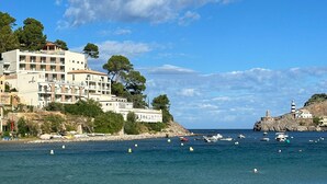 A coastal hotel with multiple floors, a sandy beach, and a clear blue sky. - Hotel Salino Port Soller - Adults Only +16 (Sóller)