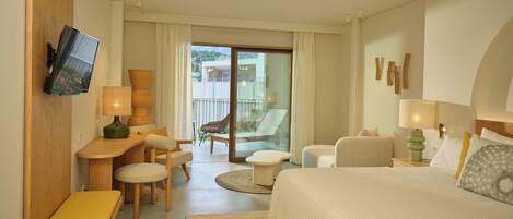 A hotel room with a bed, a desk with a chair, a television, and a view of the outside balcony.