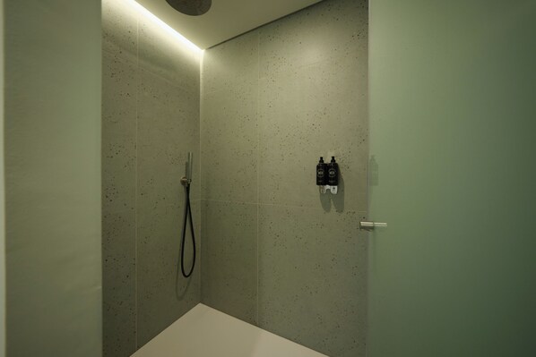 A modern bathroom with a shower, a toilet, and a sink.