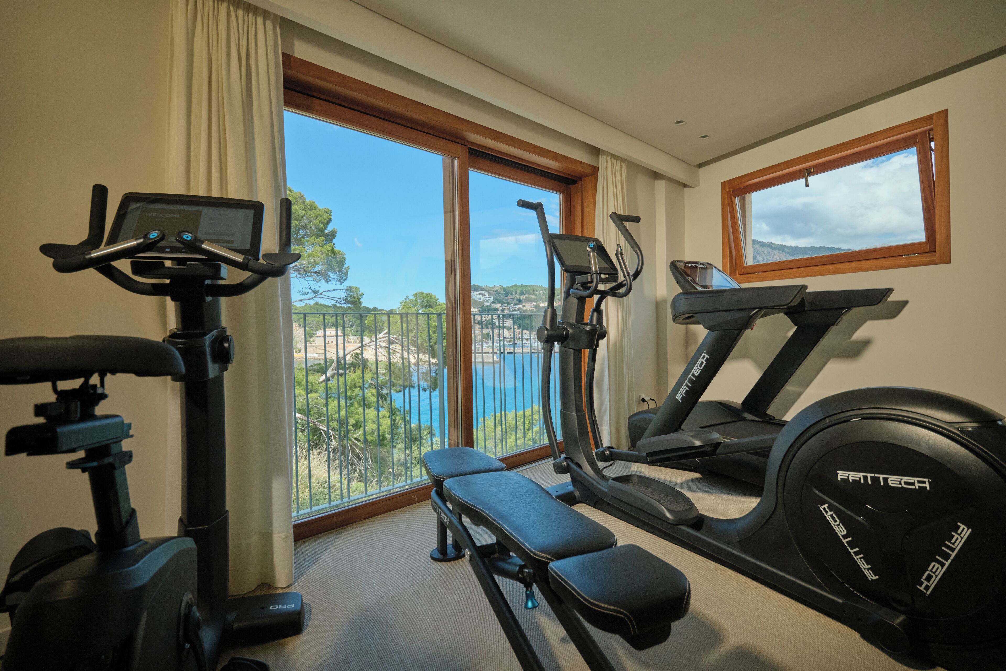 A home gym with an elliptical, a stationary bike, and a treadmill.
