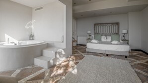 Et moderne badeværelse med et fristående badekar, et stort spejl og et toiletbord.